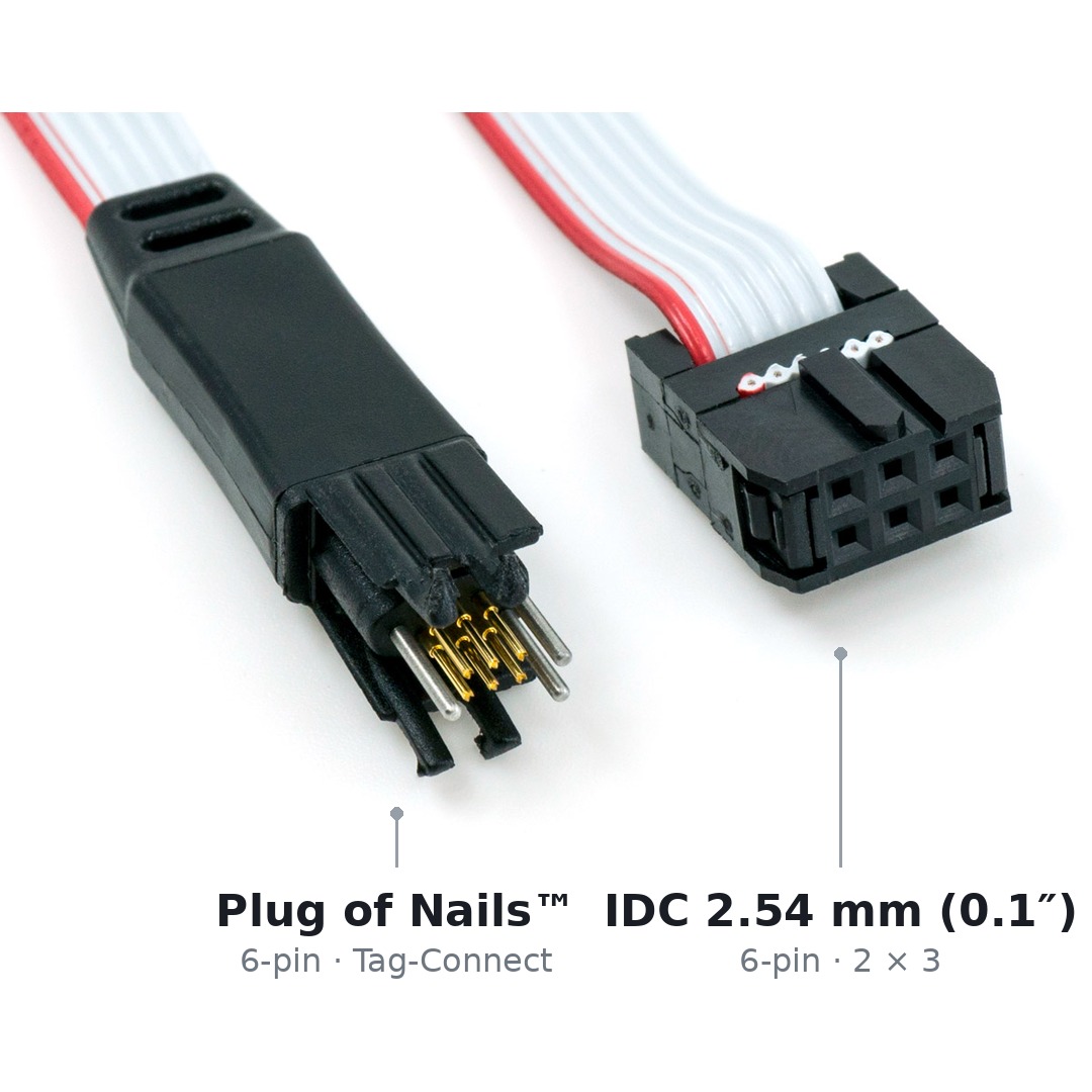 Both ends of the TC2030-IDC cable side by side: on the left the 6-pin Tag-Connect connector with spring pins and legs, on the right the 6-pin IDC connector on a 2.54 mm pitch.